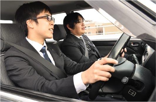 ドライバー未経験者のための同乗研修の様子です。経験豊富なベテラン社員が同乗し、ノウハウをいちから指導します。